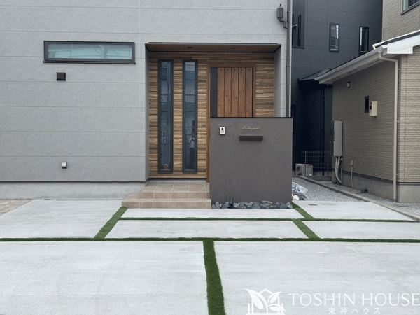 おしゃれな塗壁門柱と人工芝のスリット